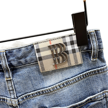 Siuvinėtos džinsinės kelnės su skylutėmis. Vyriškos užsienio prekybos tarpvalstybinio lokomotyvo madingos firminės elastinės, plonos, siuvinėtos kelnės.