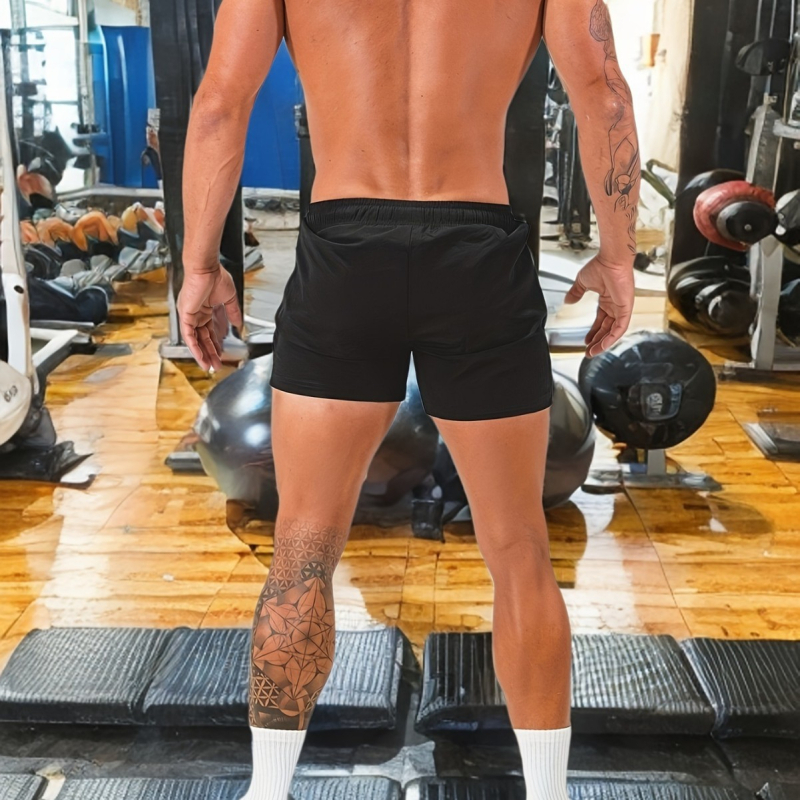 Väliskaubanduse spordikiiresti kuivavad lühikesed püksid Piiriülesed suvised laos Keskmise vöökohaga meeste voodrita kolmepunktilised lühikesed püksid, millel on hele plaat.