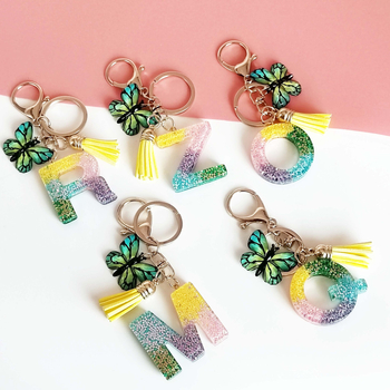 Ristäärisega 26 initsiaali vikerkaare järkjärgulise tutiga liblika ripatsiga võtmehoidja, litritega liimvaigust võtmehoidja