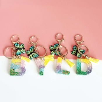 Ristäärisega 26 initsiaali vikerkaare järkjärgulise tutiga liblika ripatsiga võtmehoidja, litritega liimvaigust võtmehoidja