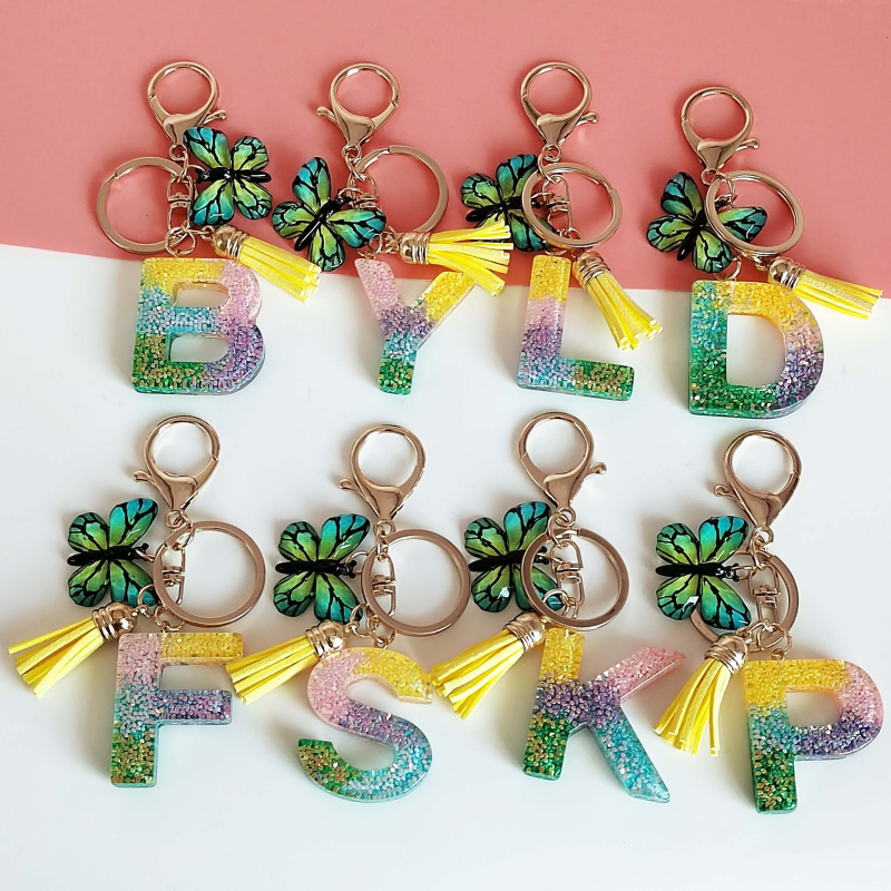 Ristäärisega 26 initsiaali vikerkaare järkjärgulise tutiga liblika ripatsiga võtmehoidja, litritega liimvaigust võtmehoidja