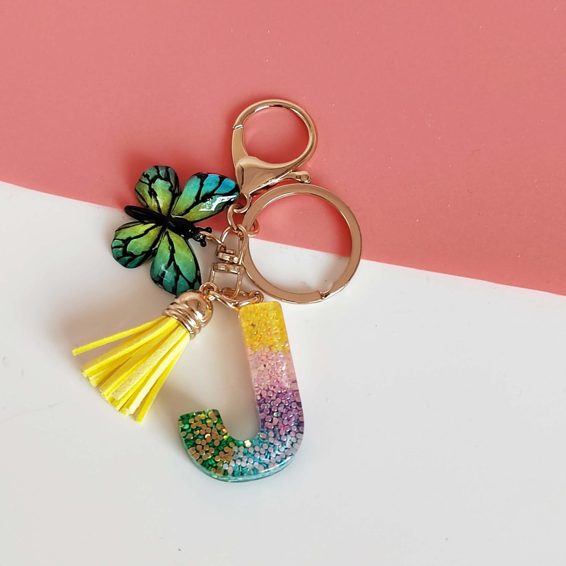 Ristäärisega 26 initsiaali vikerkaare järkjärgulise tutiga liblika ripatsiga võtmehoidja, litritega liimvaigust võtmehoidja