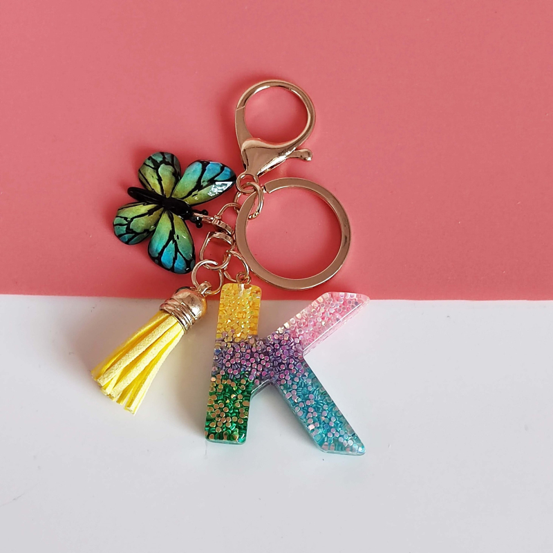 Ristäärisega 26 initsiaali vikerkaare järkjärgulise tutiga liblika ripatsiga võtmehoidja, litritega liimvaigust võtmehoidja