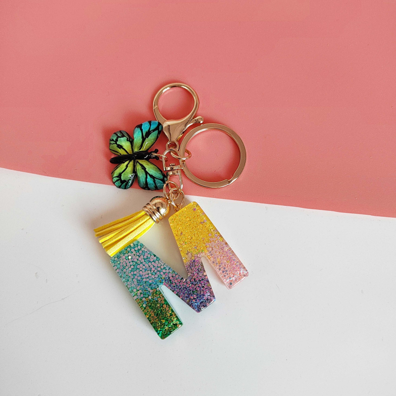 Ristäärisega 26 initsiaali vikerkaare järkjärgulise tutiga liblika ripatsiga võtmehoidja, litritega liimvaigust võtmehoidja