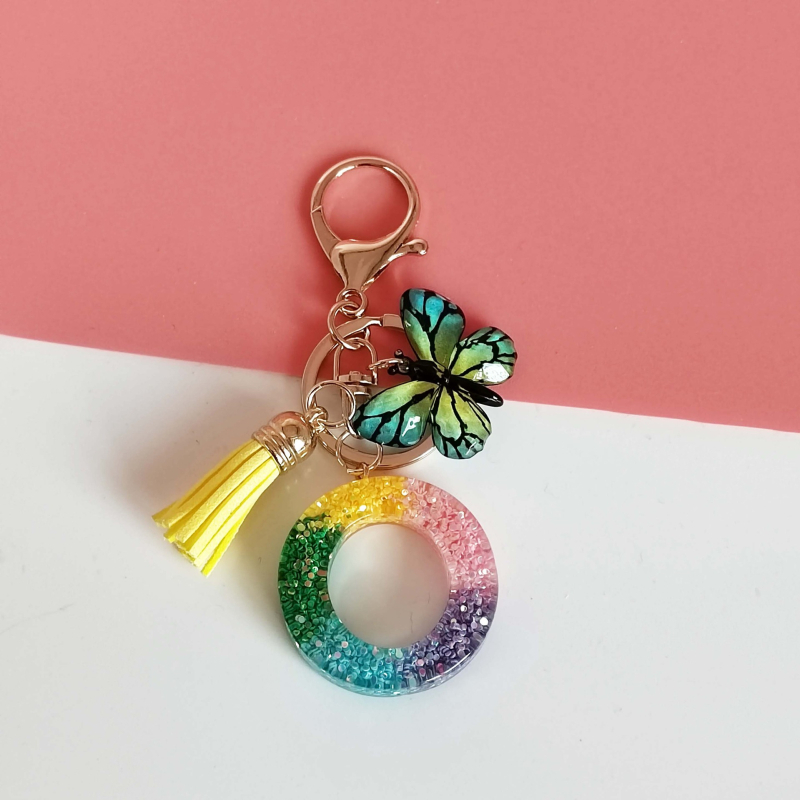 Ristäärisega 26 initsiaali vikerkaare järkjärgulise tutiga liblika ripatsiga võtmehoidja, litritega liimvaigust võtmehoidja