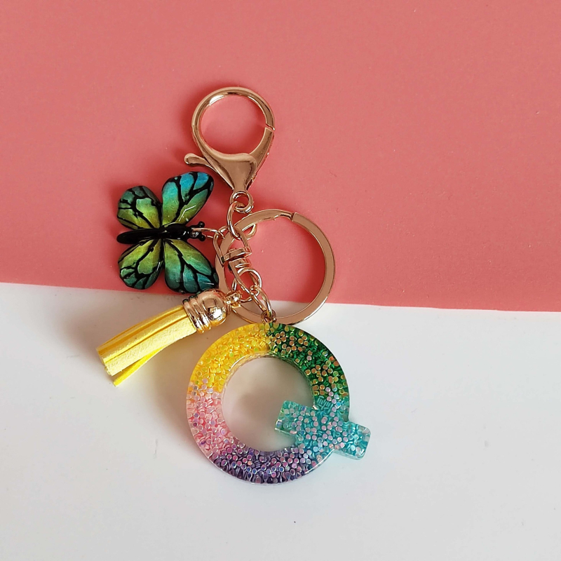 Ristäärisega 26 initsiaali vikerkaare järkjärgulise tutiga liblika ripatsiga võtmehoidja, litritega liimvaigust võtmehoidja