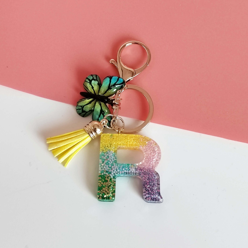 Ristäärisega 26 initsiaali vikerkaare järkjärgulise tutiga liblika ripatsiga võtmehoidja, litritega liimvaigust võtmehoidja