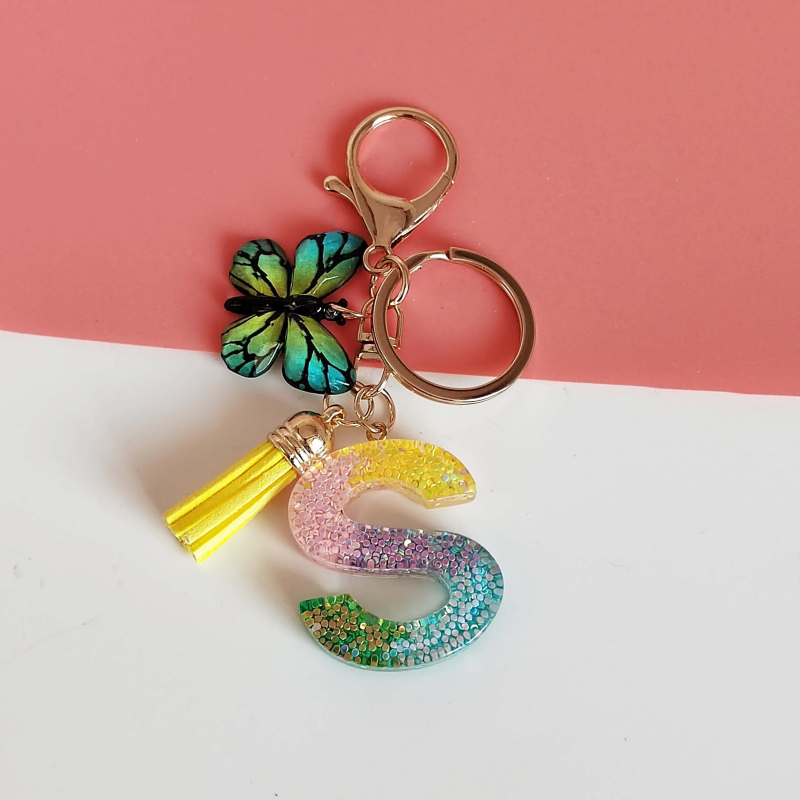 Ristäärisega 26 initsiaali vikerkaare järkjärgulise tutiga liblika ripatsiga võtmehoidja, litritega liimvaigust võtmehoidja