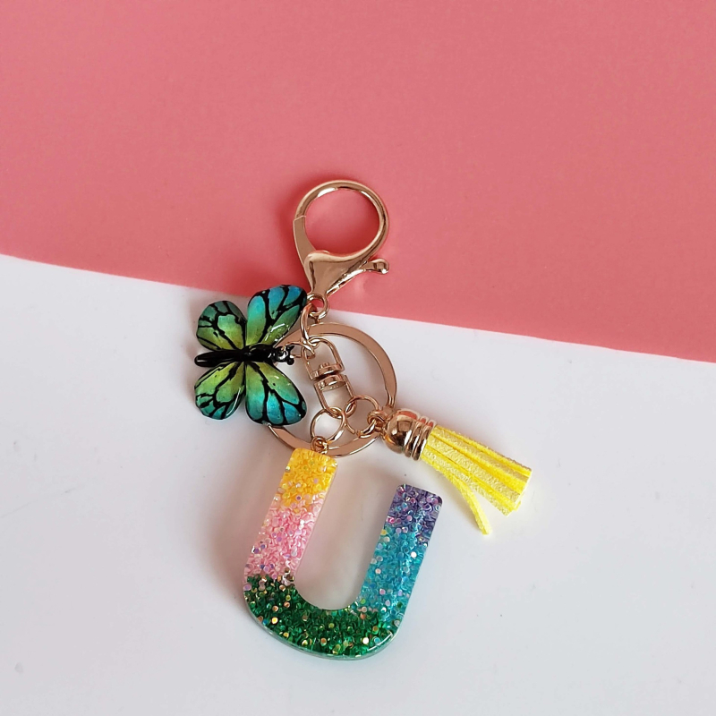 Ristäärisega 26 initsiaali vikerkaare järkjärgulise tutiga liblika ripatsiga võtmehoidja, litritega liimvaigust võtmehoidja