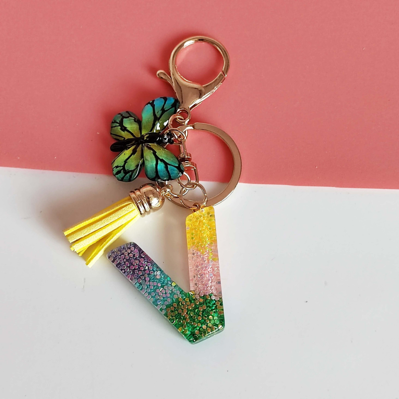 Ristäärisega 26 initsiaali vikerkaare järkjärgulise tutiga liblika ripatsiga võtmehoidja, litritega liimvaigust võtmehoidja