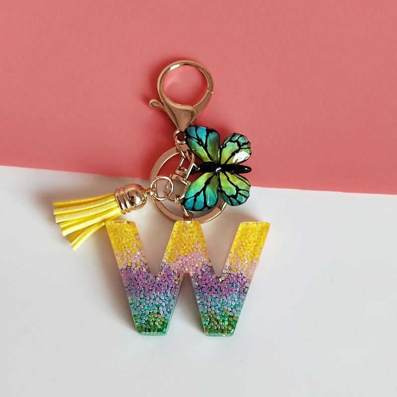 Ristäärisega 26 initsiaali vikerkaare järkjärgulise tutiga liblika ripatsiga võtmehoidja, litritega liimvaigust võtmehoidja