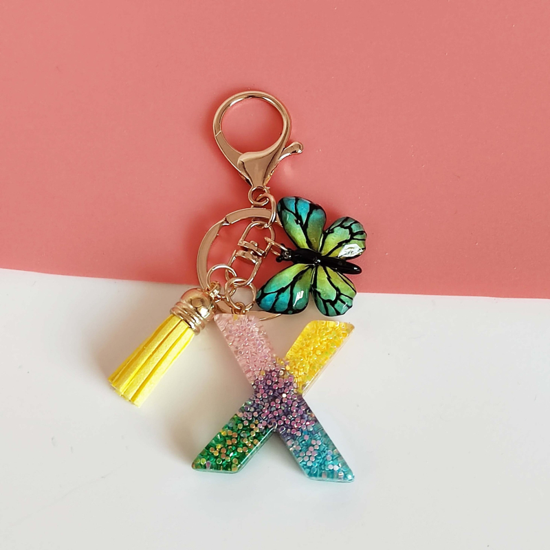 Ristäärisega 26 initsiaali vikerkaare järkjärgulise tutiga liblika ripatsiga võtmehoidja, litritega liimvaigust võtmehoidja