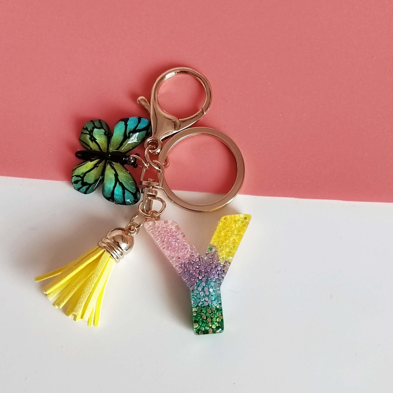 Ristäärisega 26 initsiaali vikerkaare järkjärgulise tutiga liblika ripatsiga võtmehoidja, litritega liimvaigust võtmehoidja