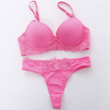 Moteriškos seksualios saldainių spalvos liemenėlės komplektas su apatiniais, vienspalviais nėriniuotais marškinėliais, seksualus pilvo preso kaušelis.