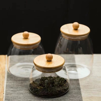 Skaidrus stiklinis arbatos indelis, kvapnus arbatos indelis, juodos arbatos buteliukas, apvalus bambukinis dangtelis su sandarinimo žiedu, prieskonių laikymo indelis