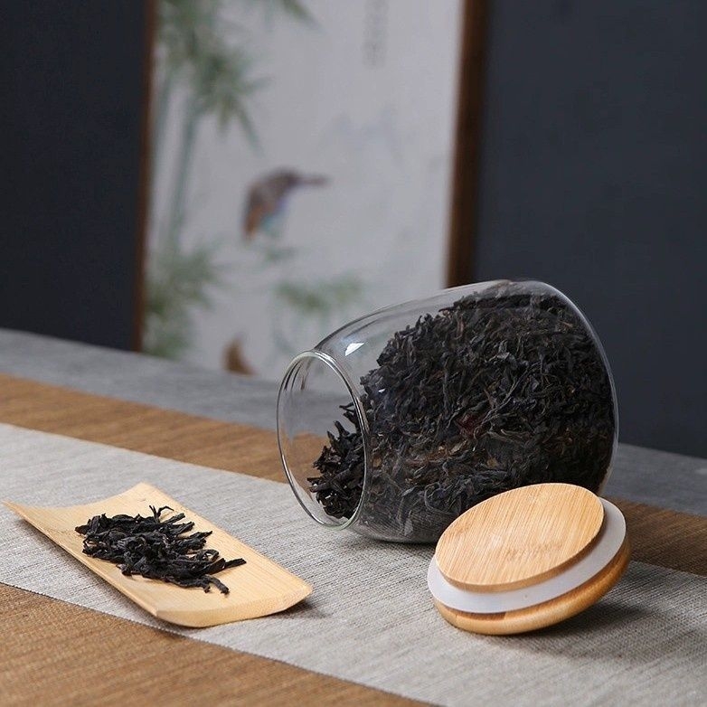 Skaidrus stiklinis arbatos indelis, kvapnus arbatos indelis, juodos arbatos buteliukas, apvalus bambukinis dangtelis su sandarinimo žiedu, prieskonių laikymo indelis