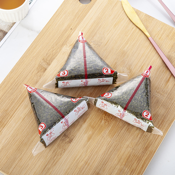 Dvisluoksnis trikampis ryžių kamuoliukų pakavimo maišelis, pusiau supjaustyti jūros dumbliai, rankomis susukta suši pakuotė, lengvai plyštanti ir nerasojanti, japoniško stiliaus jūros dumbliais apvyniota akmens masė