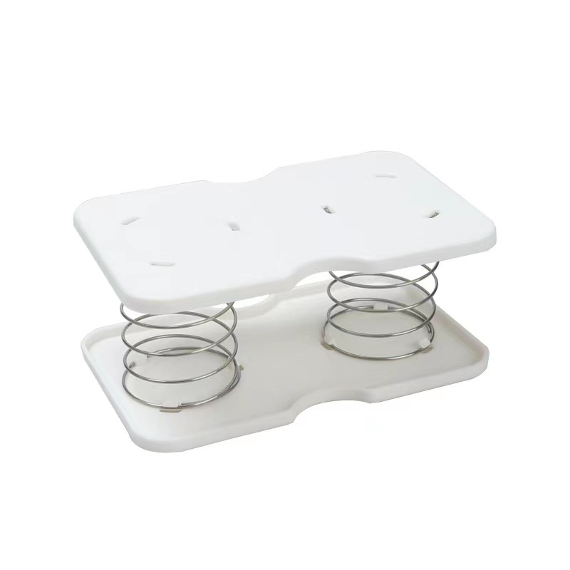 Pakeliama servetėlių dėžutės spyruoklinė atrama, skirta pritraukti prie apatinės spyruoklinės stalčiaus dėžutės apatinės atramos, laikymo dėžutės spyruoklinė lapo pakėlimo elastinė atrama