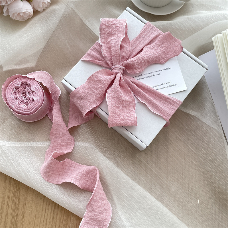 Vėjo klostuota audinio juostelė, didelis pakavimo juostelės ritinėlis, graži minkšta peteliškė, gėlių kaklaraištis