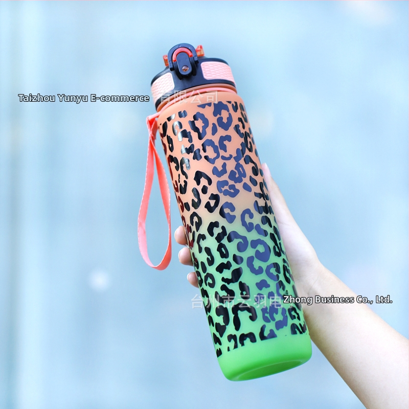 Sandėlyje yra kryžminis gradiento leopardo rašto sportinis plastikinis vandens puodelis su siurbimo vamzdeliu. Leopardo rašto sportinis vandens puodelis.