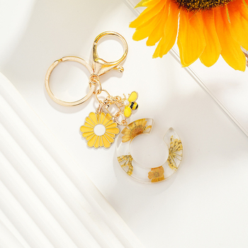 Μικρό μπρελόκ με γράμμα μαργαρίτας σε διασυνοριακές εκρήξεις, νέο μπρελόκ με φούντα, κίτρινο χρυσάνθεμο, αποξηραμένο λουλούδι, σχολική τσάντα