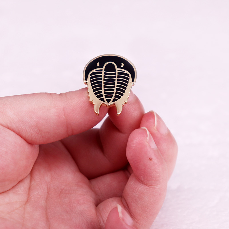 Kambro nariuotakojų išnykusio gyvūno trilobito sagė biologinės archeologijos ženklelio priedai