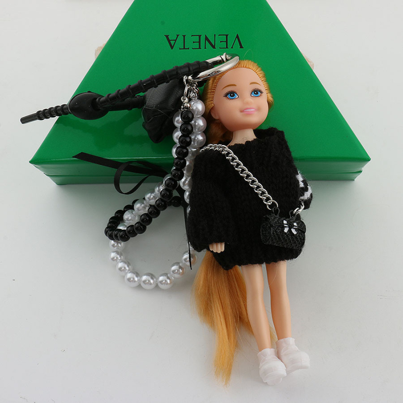 Tarpvalstybinis Jiang Paris ponia Yesha su mielu Barbie lėlės krepšiu ir pakabuku ant automobilio, raktų pakabuku ant riešo.