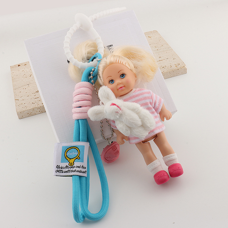 Tarpvalstybinis Jiang Paris ponia Yesha su mielu Barbie lėlės krepšiu ir pakabuku ant automobilio, raktų pakabuku ant riešo.