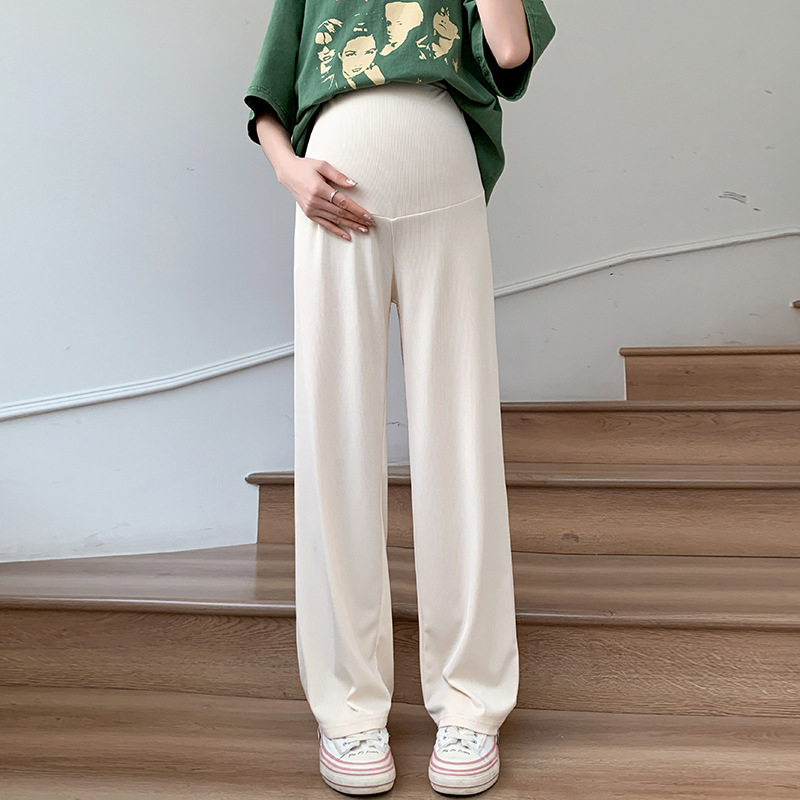 Tikra sandėlyje esančių tamprių, neblunkančių M-3XL nėščiosioms skirtų plačių kelnių nuotrauka. Vasarinės laisvos, laisvos, liekninančios kelnės su vertikaliomis juostelėmis viršutiniams drabužiams.