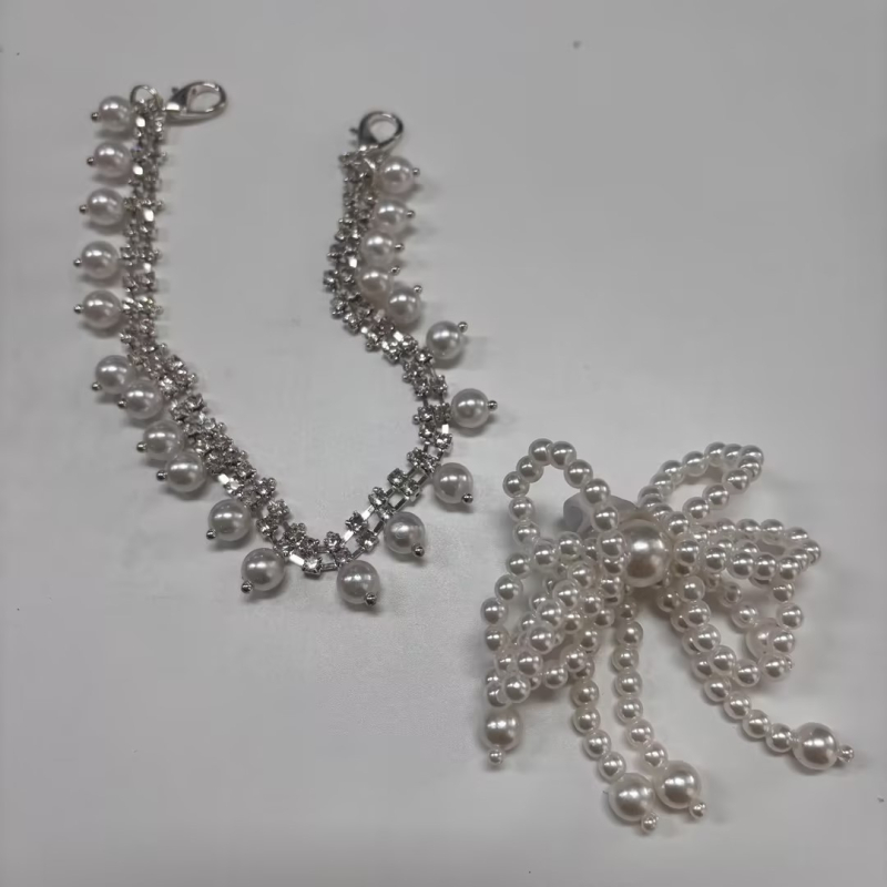 Moodne ja stiilne lipsusõlmega pärlitega tutiga, kividega kontsaga, ketiga, lillega kingapandla aksessuaar, helmestega ripats, dekoratiivne pannal