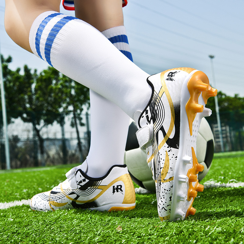 Pārrobežu vairumtirdzniecības bērnu futbola apavi ar garajām radzēm, mākslīgā zāliena sacensībām, vīriešu un sieviešu studentu bērnu treniņu apavi ar salauztām radzēm