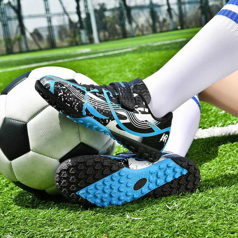 Pārrobežu vairumtirdzniecības bērnu futbola apavi ar garajām radzēm, mākslīgā zāliena sacensībām, vīriešu un sieviešu studentu bērnu treniņu apavi ar salauztām radzēm