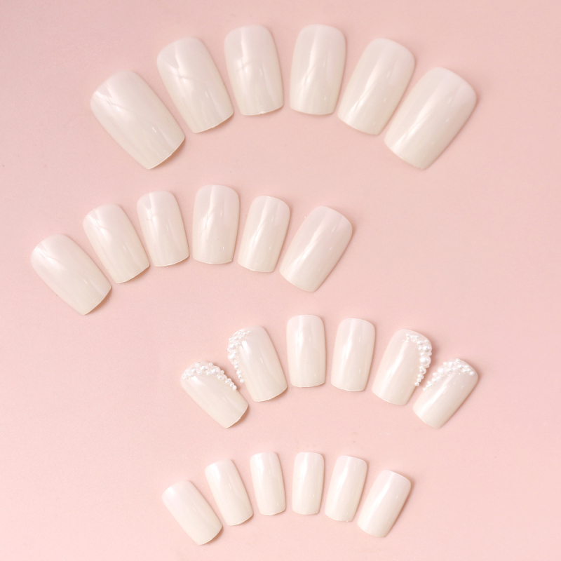 Dėvėkite vientisos spalvos trumpą baltą nagų dailės kūrinį, pagamintą iš stačiakampių dirbtinių nagų, skirtų tarpvalstybinei užsienio prekybai.