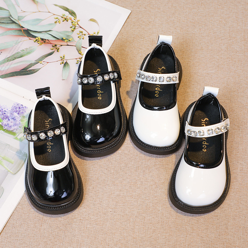 Studentiški maži odiniai bateliai su cirkoniais, 2025 m. rudens nauji koledžo stiliaus vaikiški mokykliniai juodi sportiniai bateliai mergaitiškiems, ant podiumo.