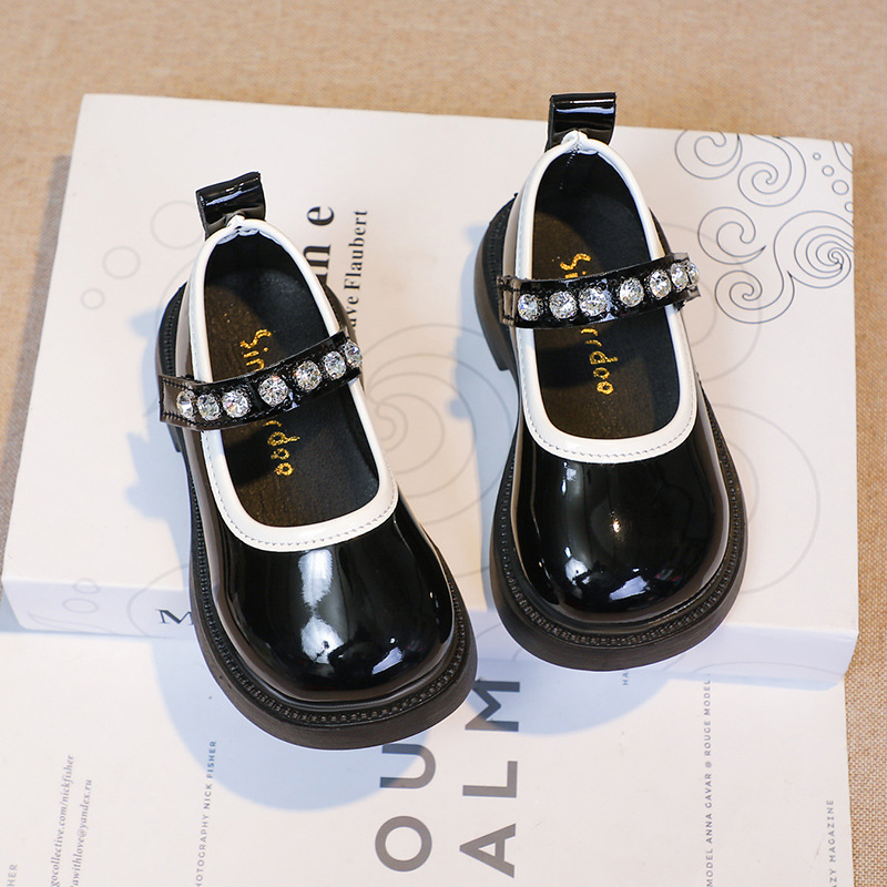 Studentiški maži odiniai bateliai su cirkoniais, 2025 m. rudens nauji koledžo stiliaus vaikiški mokykliniai juodi sportiniai bateliai mergaitiškiems, ant podiumo.