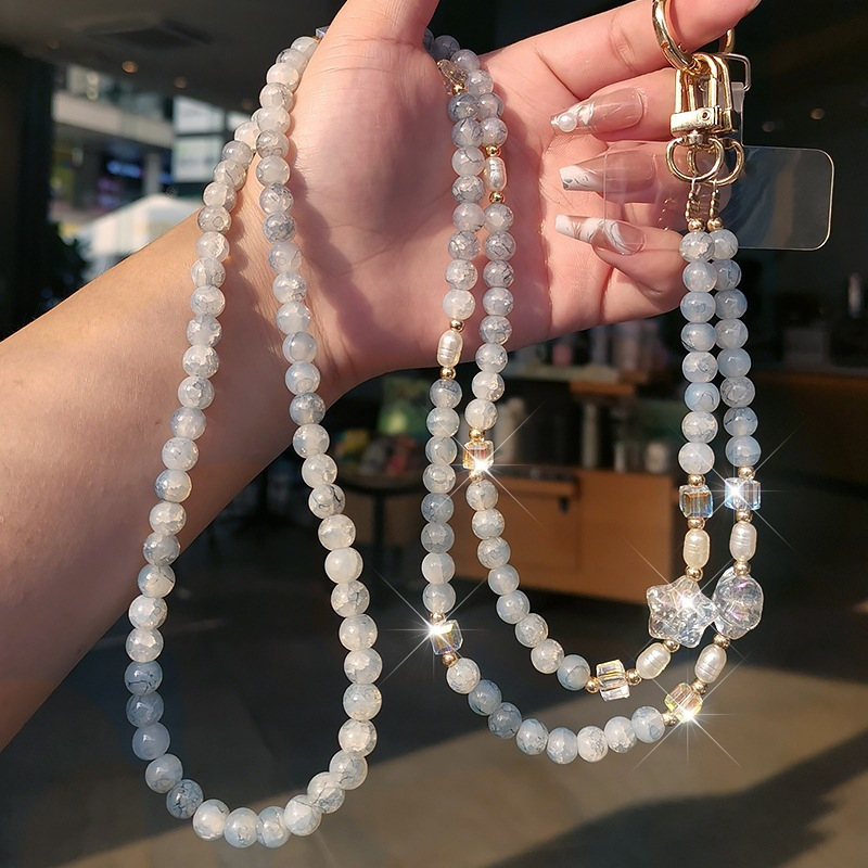 Ilgas mobiliojo telefono dirželis su įtrūkusiais karoliukais, krištolo karoliukų grandinėlė, išskirtinis jūrų žvaigždės karoliukų maišelis su grandinėle, pakabukas mobiliojo telefono dėklui, apsaugantis nuo pametimo.