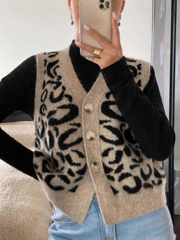 Vesta cardigan tricotat cu imprimeu leopard, decolteu în V, fără mâneci, lungime 50–65 cm, închidere cu nasturi multiple