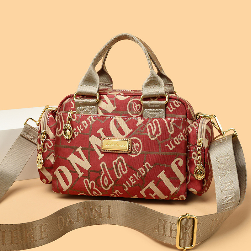 Női vízálló Oxford anyagú táska, kompakt négyszöges alak, cipzáras nyitás, belső zsebek (telefon, ID), poliészter bélés