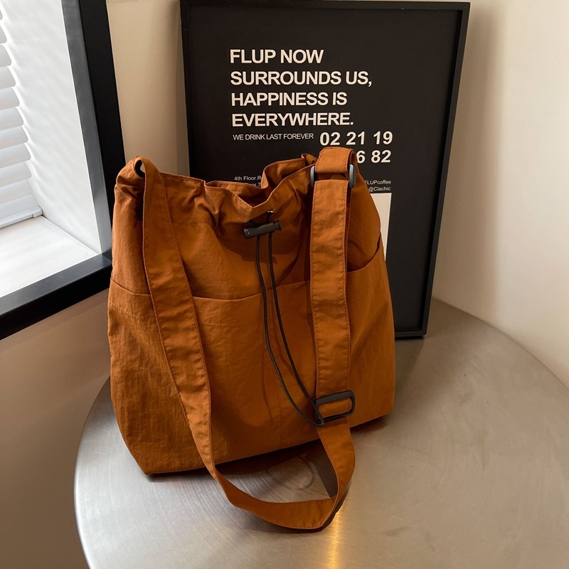 Casual ženska nylon tote torba; vertikalni kvadratni oblik, magnetsko zatvaranje, poliester podstava, unutarnje džepove za telefon i karticu identifikacije.