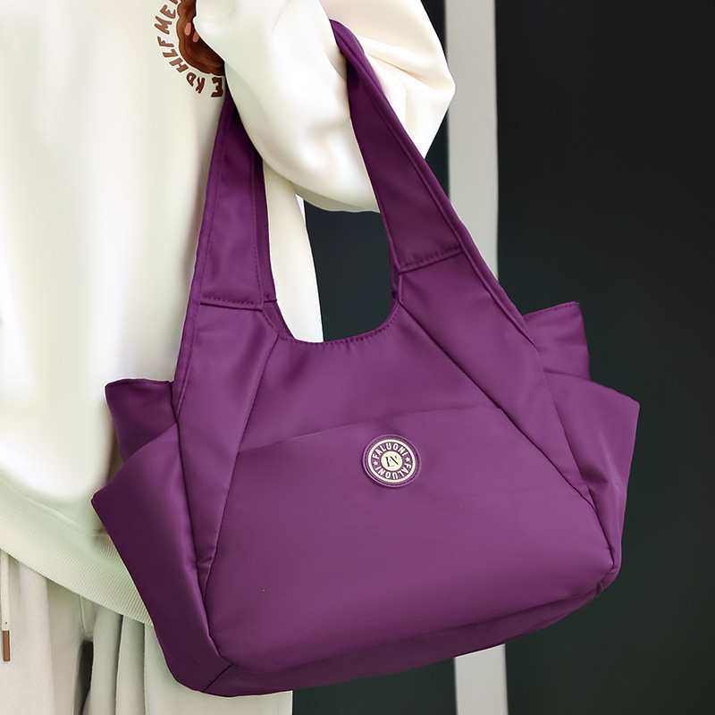 Nylonová tote taška, horizontálny štvorcový tvar, zapínanie na zips, vnútorné vrecká (zipsové vrecko, vrecko na telefón, vrecko na ID), dvojité popruhy