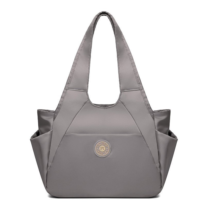 Nylonová tote taška, horizontálny štvorcový tvar, zapínanie na zips, vnútorné vrecká (zipsové vrecko, vrecko na telefón, vrecko na ID), dvojité popruhy