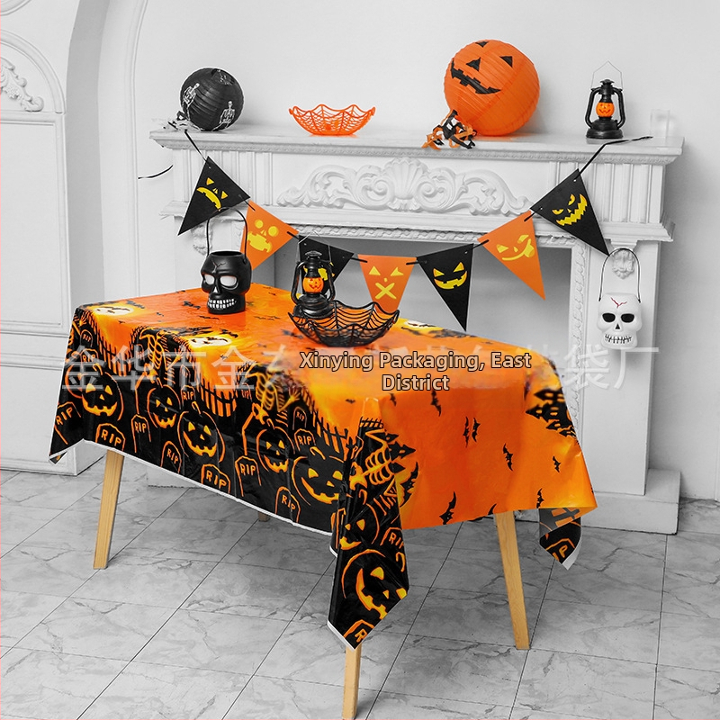 Jednorázový plastový obrus na Halloween párty s motívmi tekvice, lebky a netopiera v štýle karikatúrneho hororu.