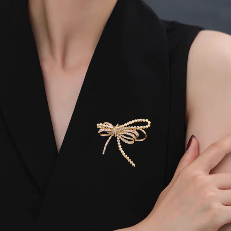 Rézből készült masni alakú brooch mikro-beültetett cirkóniával és gyöngyökkel, elegáns könnyed luxus, 2025 nyár
