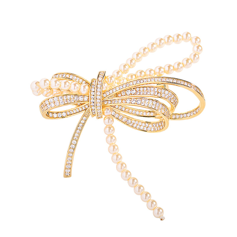 Rézből készült masni alakú brooch mikro-beültetett cirkóniával és gyöngyökkel, elegáns könnyed luxus, 2025 nyár