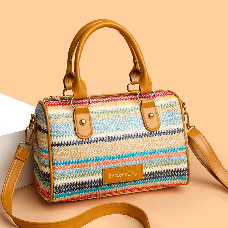 Szalmából készült váll- és keresztpántos táska hengeres alakban, cipzáras zárás, poliészter bélés, belső zseb