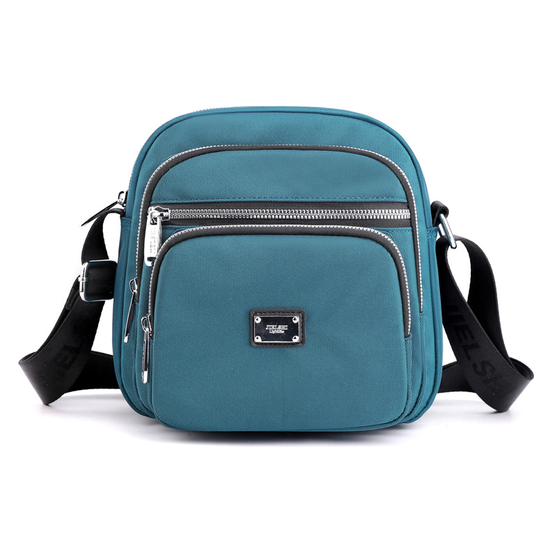 Oxford anyagú crossbody táska, városi letisztultság, kis négyzet alakú, horizontális forma, cipzáras zárás