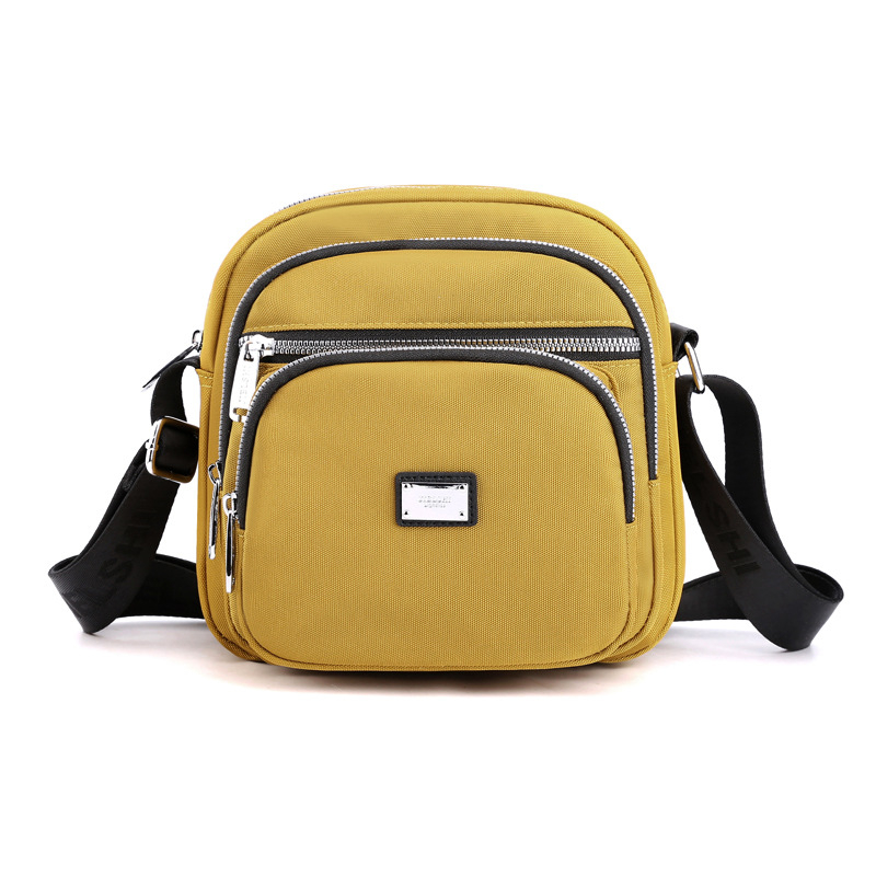 Oxford anyagú crossbody táska, városi letisztultság, kis négyzet alakú, horizontális forma, cipzáras zárás