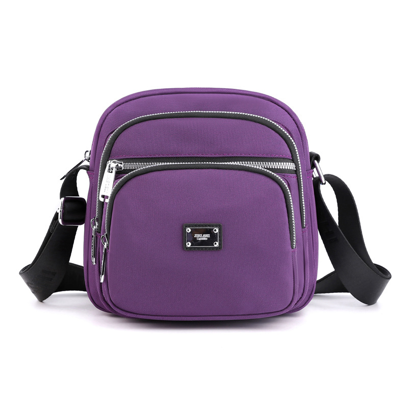 Oxford anyagú crossbody táska, városi letisztultság, kis négyzet alakú, horizontális forma, cipzáras zárás