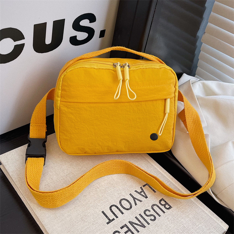 Női nylonos crossbody táska, vízszintes négyzet alakú, belső zseb telefon és személyi igazolvány számára, cipzáras záródás, poliészter bélés, mindennapi használatra