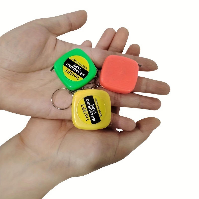 Mini kabatas mērlente apģērbam un ķermeņa apmēriem — pārnēsājams šuvēja mērlente, metāls + plastiks, kvadrātveida forma, apmēram 13 g, drukāts logo, piemērots dāvanai